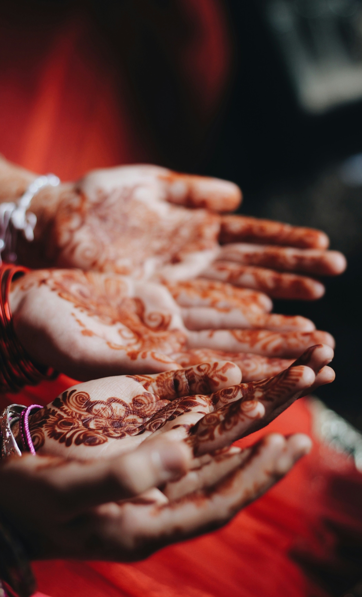 Two sets of hands covered in Henna tattoos.