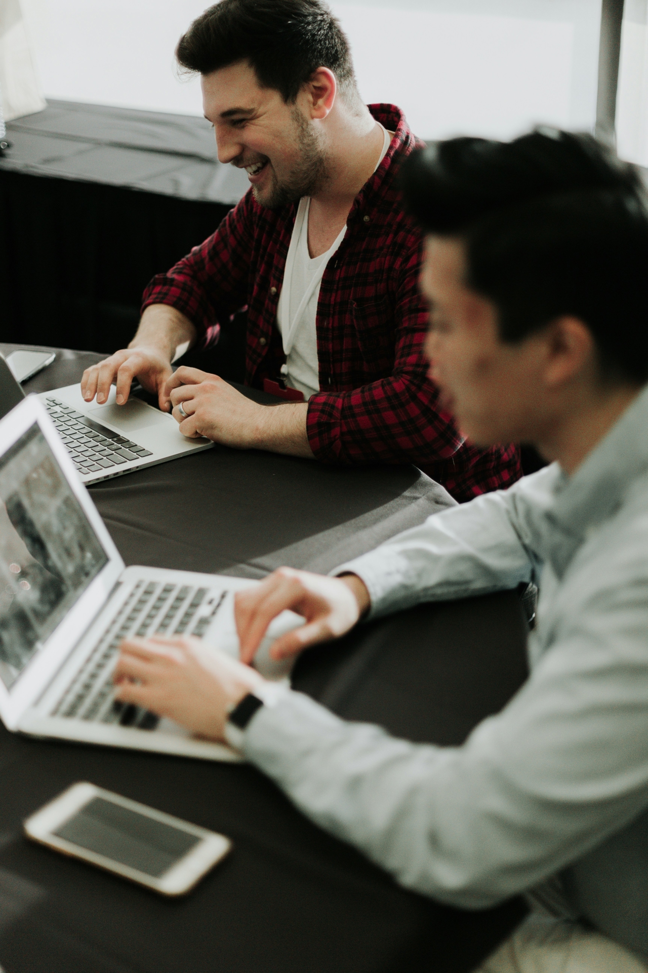 Two migrants sitting in front of computers at their new workplace.