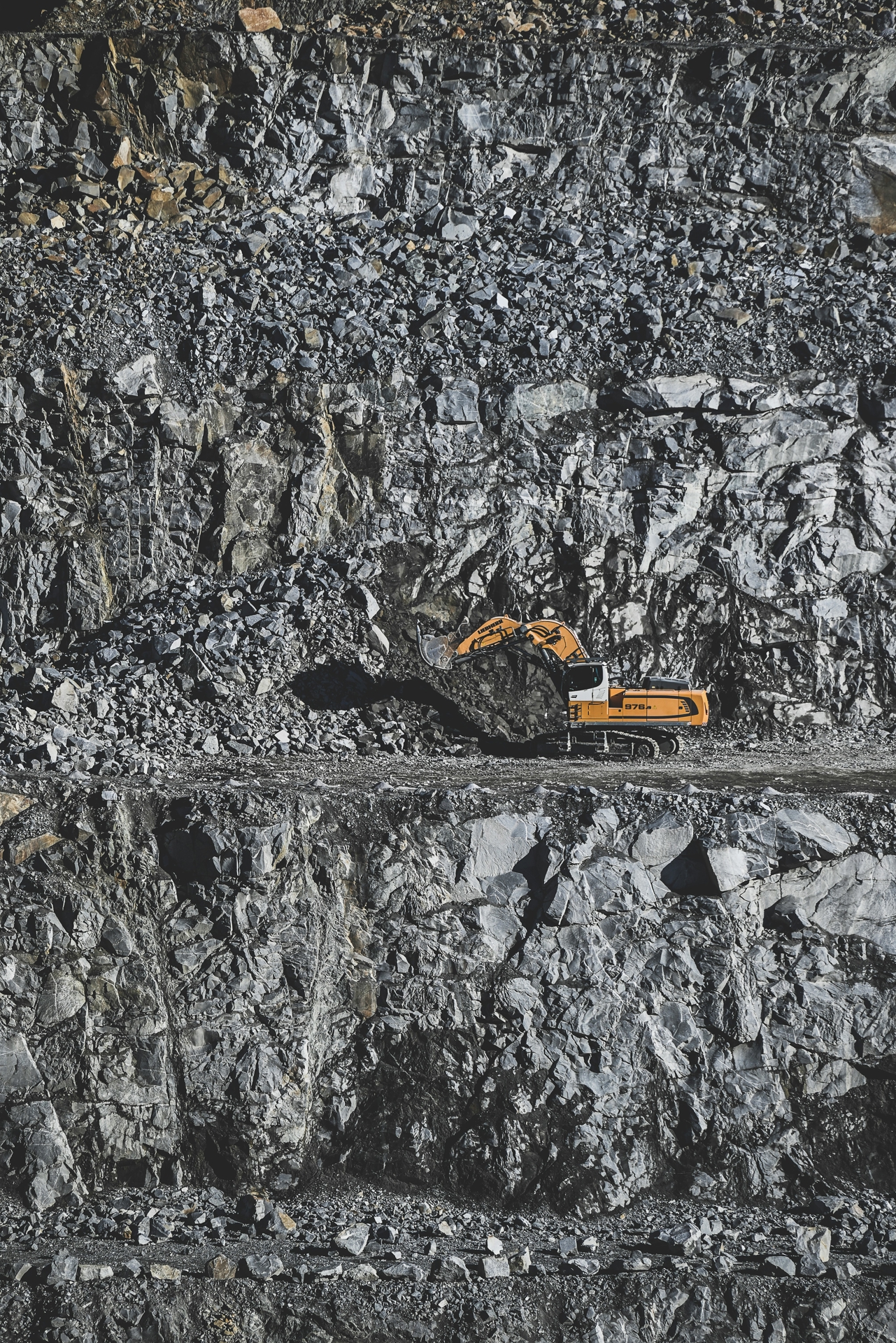 Orange digging machine in a stone quarry.