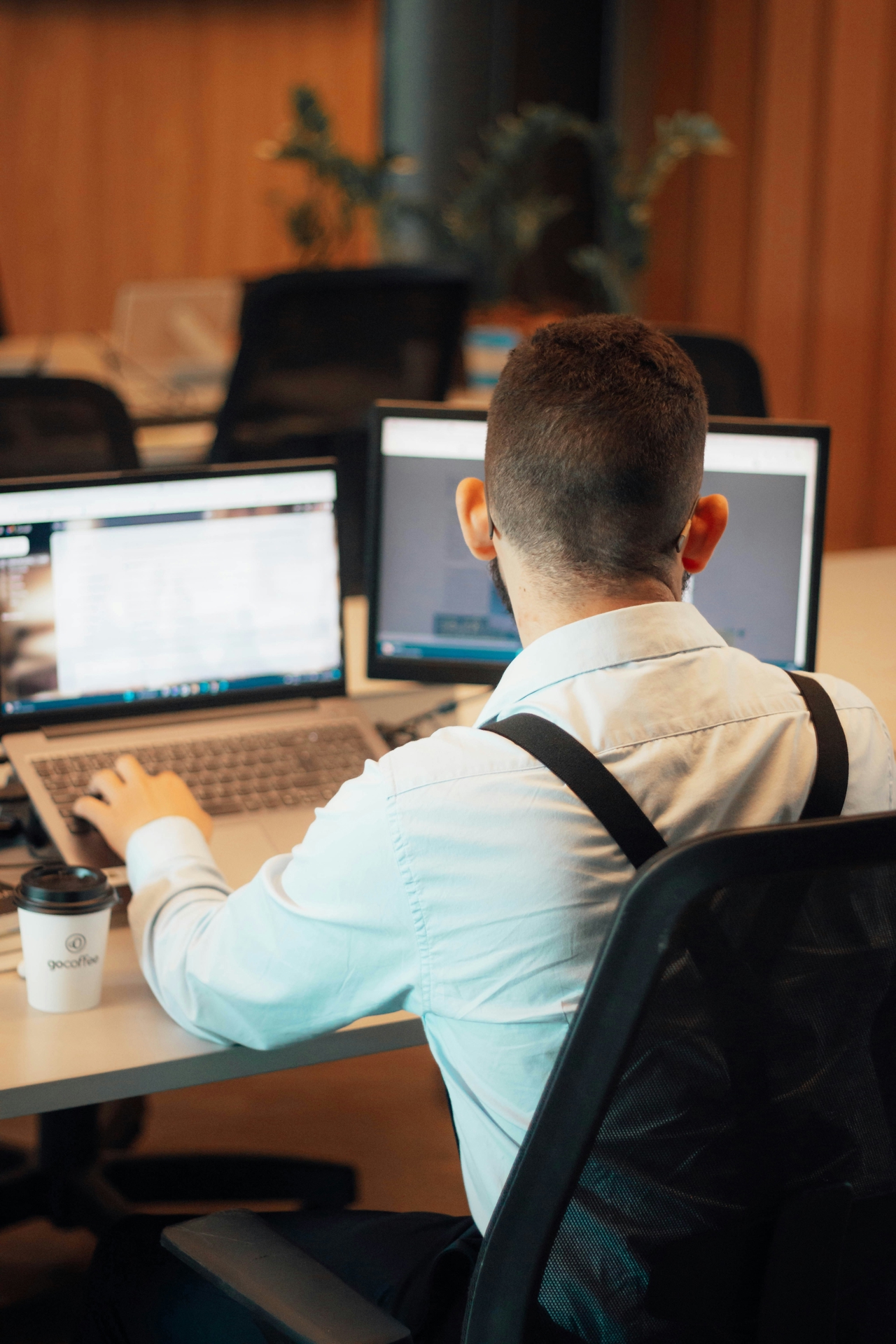 Employee working in front of a computer with his back to the camera.