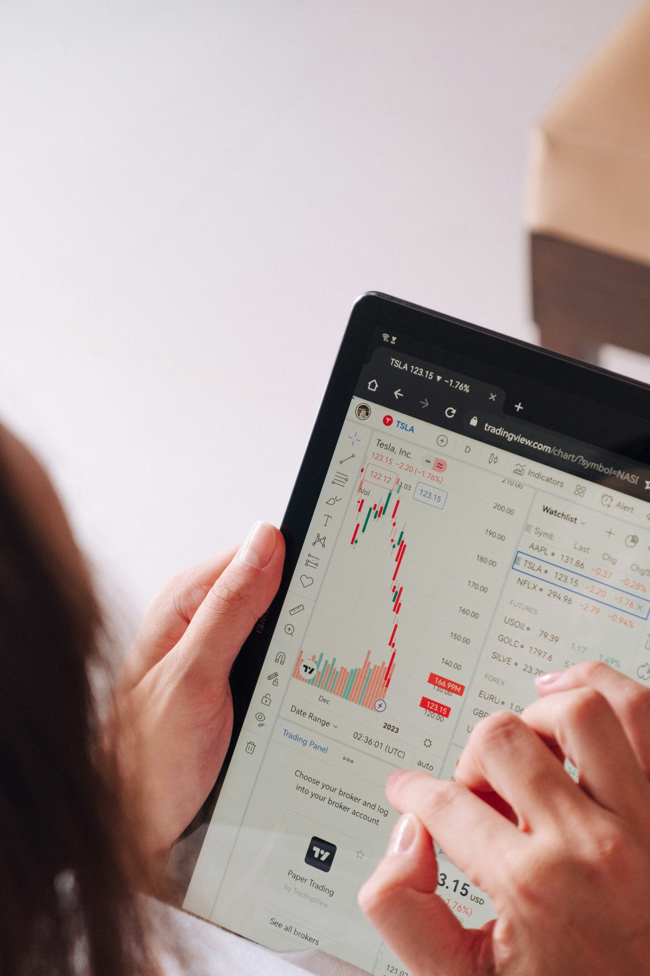 Person holding a tablet in both hand, checking the stock market.