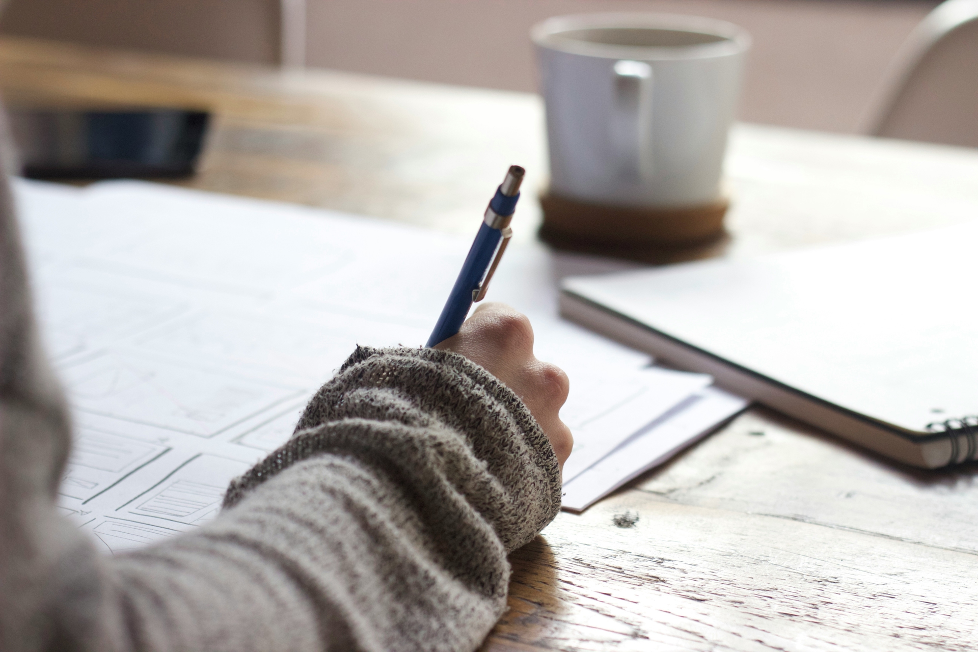 Woman holding a pen, writing on a piece of paper